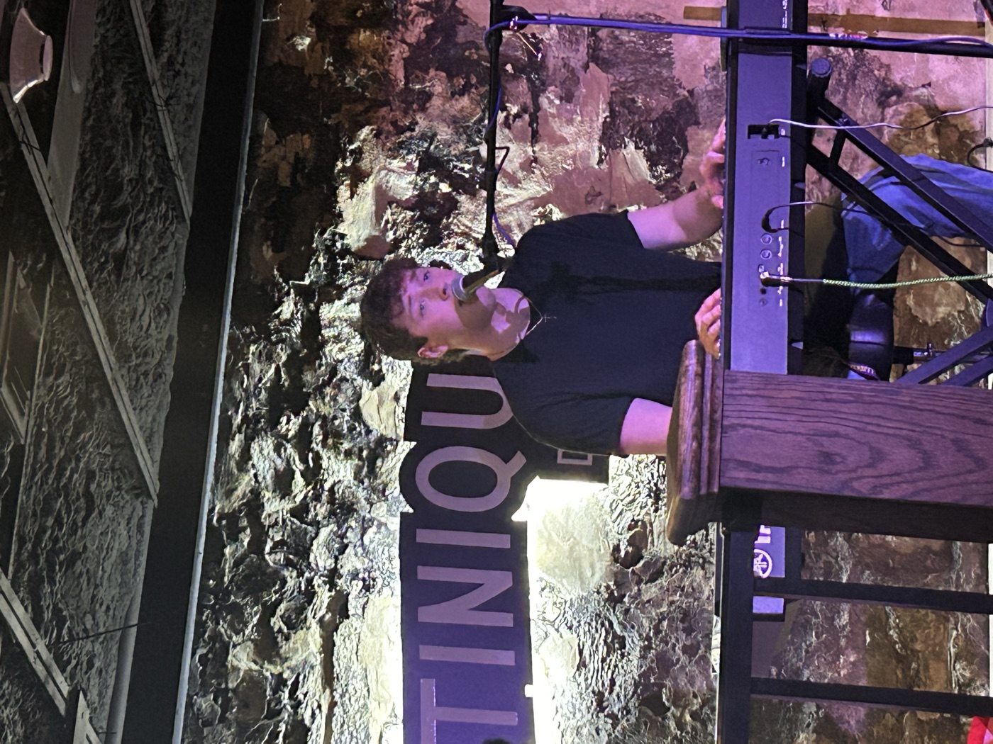 Aidan Boyce singing at the keyboard, on stage at the Martinique